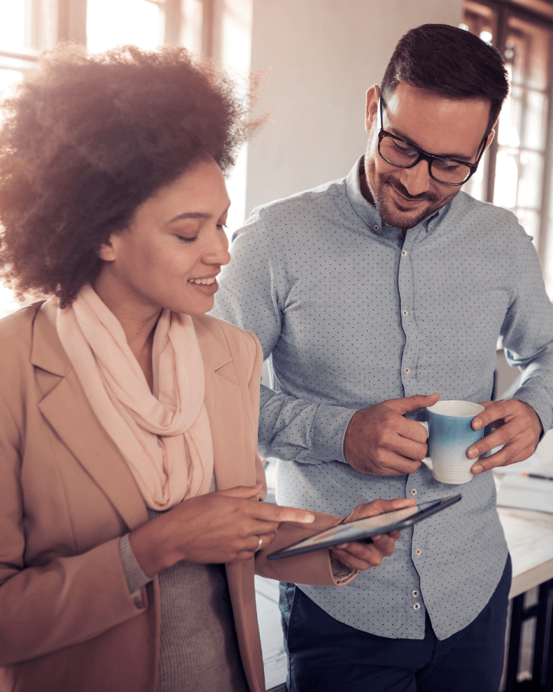 Photo of two people looking at a tablet.